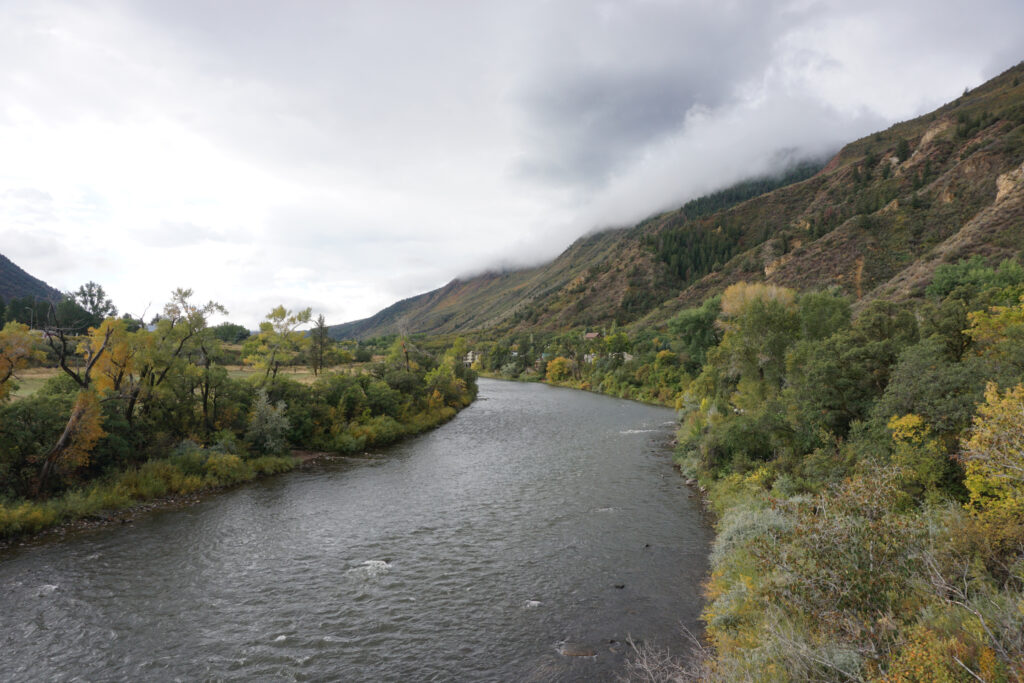 A mountainous landscape with a river at the base of the mountain