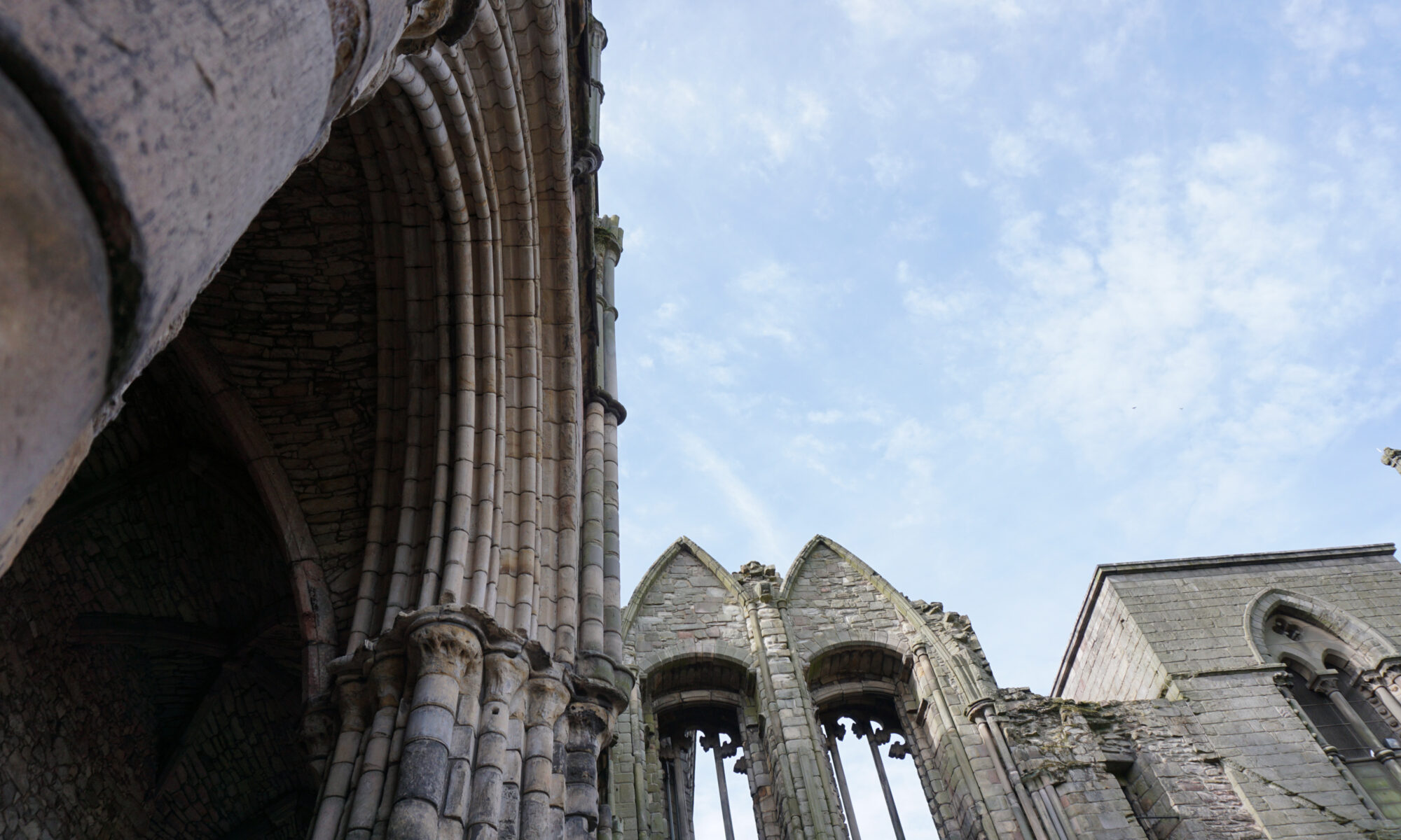 This photo shows stone ruins, with an upward angle showing a blue sky.