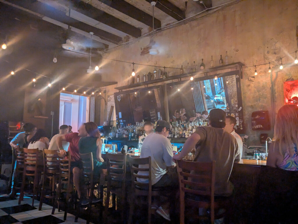 The Front Bar at La Factoria in Old San Juan, Puerto Rico. A bar lined with seats, a mirror on the back wall.