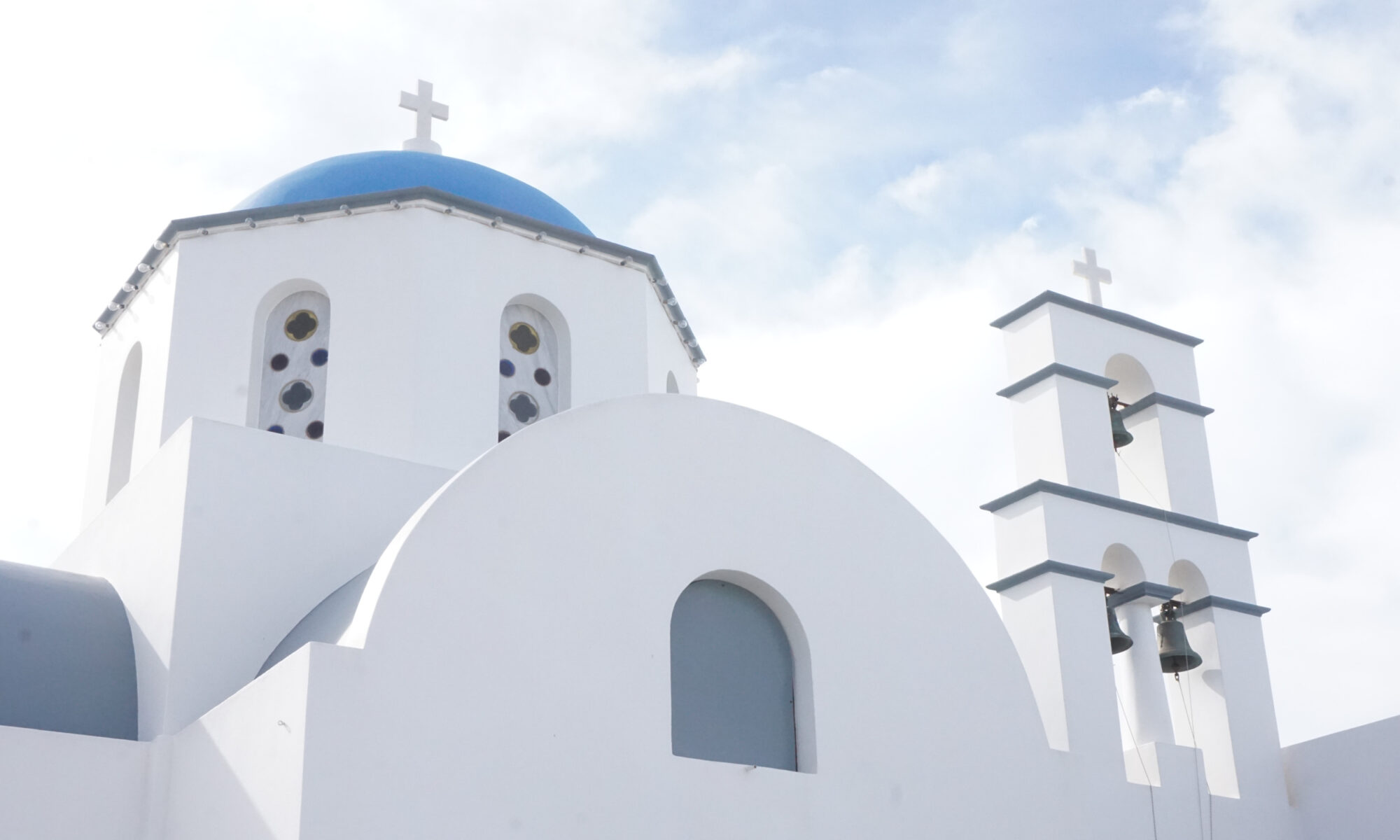 A white-washed church with a blue top