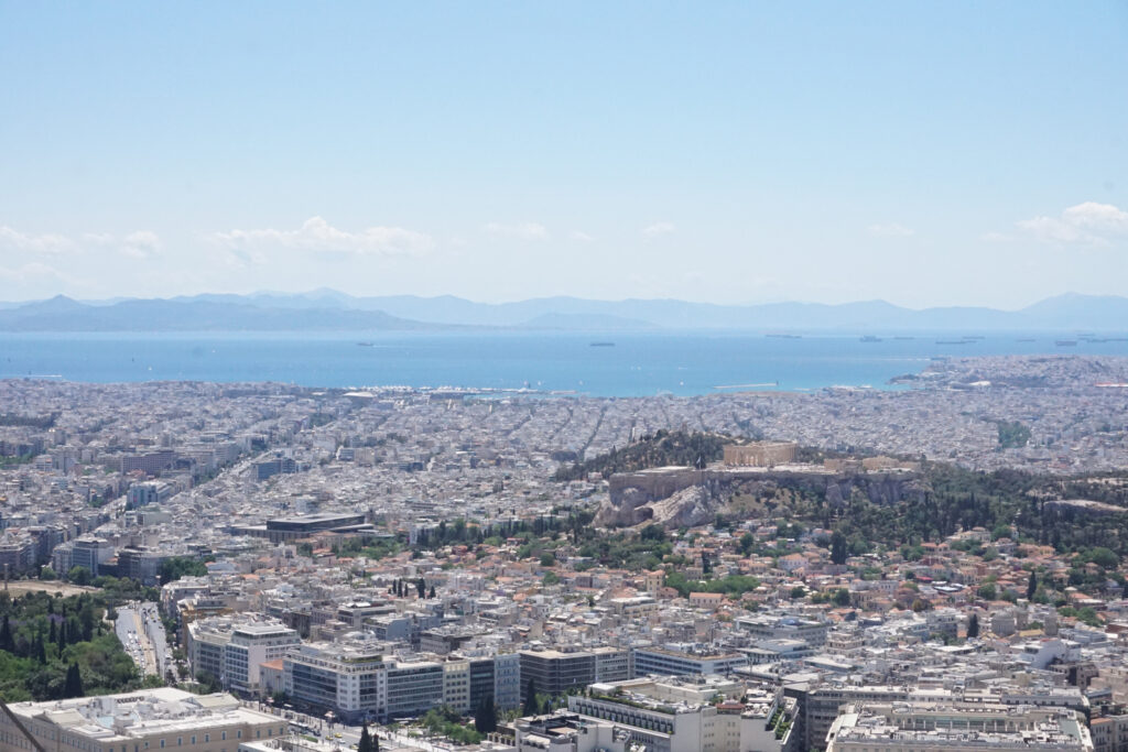 A cityscape of Athens from on top of a hill, looking out to sea
